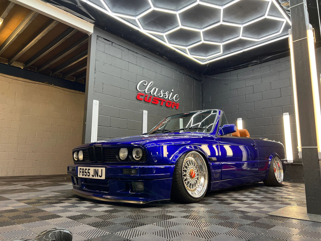 Blue classic BMW E30 cabriolet displayed inside the Classic Custom workshop